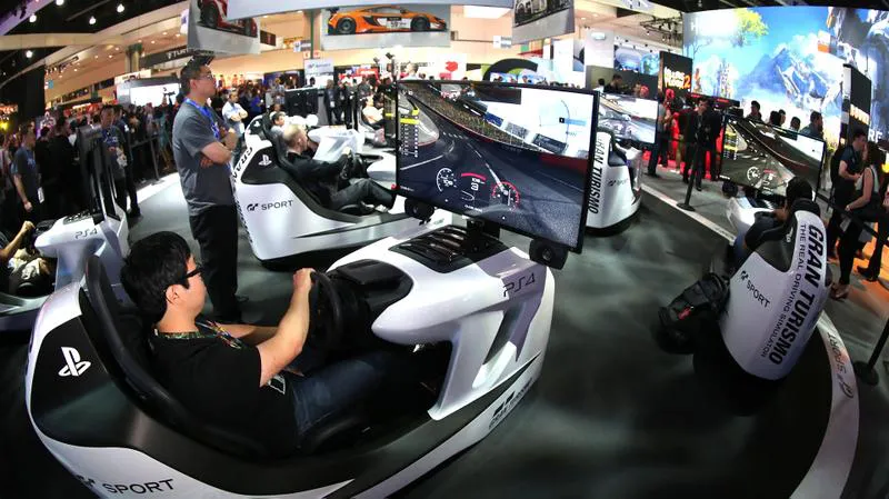 Los asistentes prueban el videojuego Gran Turismo de PlayStation